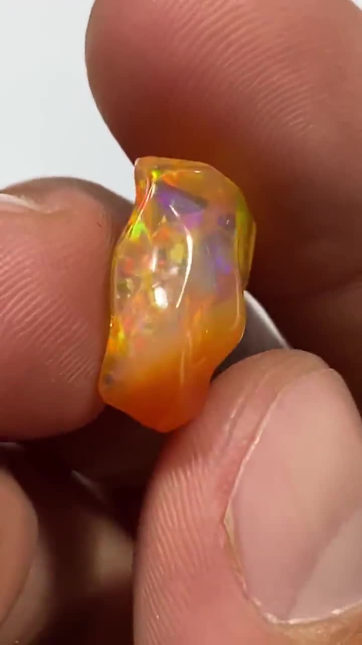 amazing fire opal with its dazzling purple sparkles and beautiful scenery   weight 22.80 carats measure 22x8x9mm